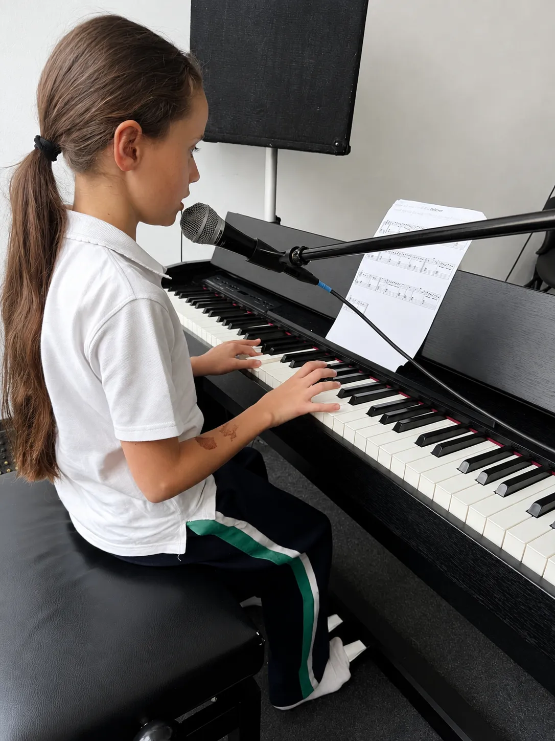 Uczennica śpiewa i gra na pianinie podczas lekcji w Bieganowska Music Academy